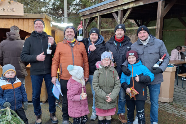 Eine Gruppe Menschen lächelt den Fotografen an